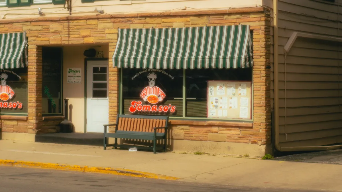 Storefront sign for a small local business on a sunlit street