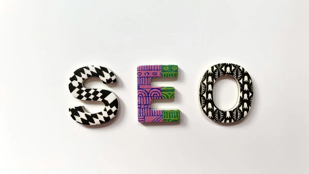 The letters S, E, and O crafted from patterned wooden tiles on a white background